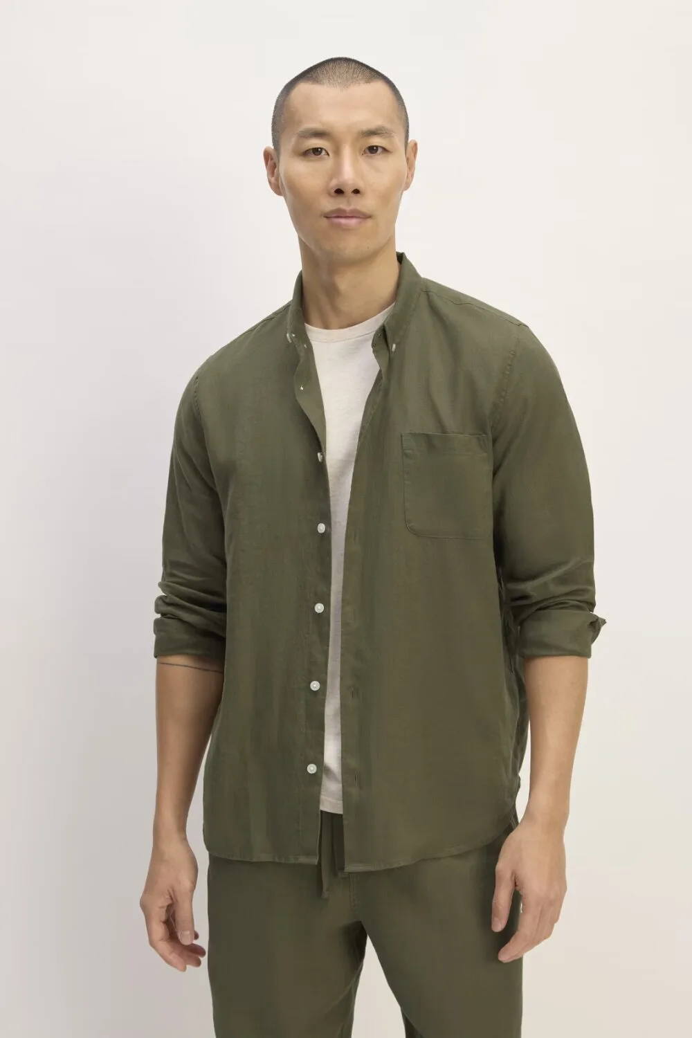 Olive linen button-up shirt with rolled sleeves – a breathable summer essential for men in 2025.