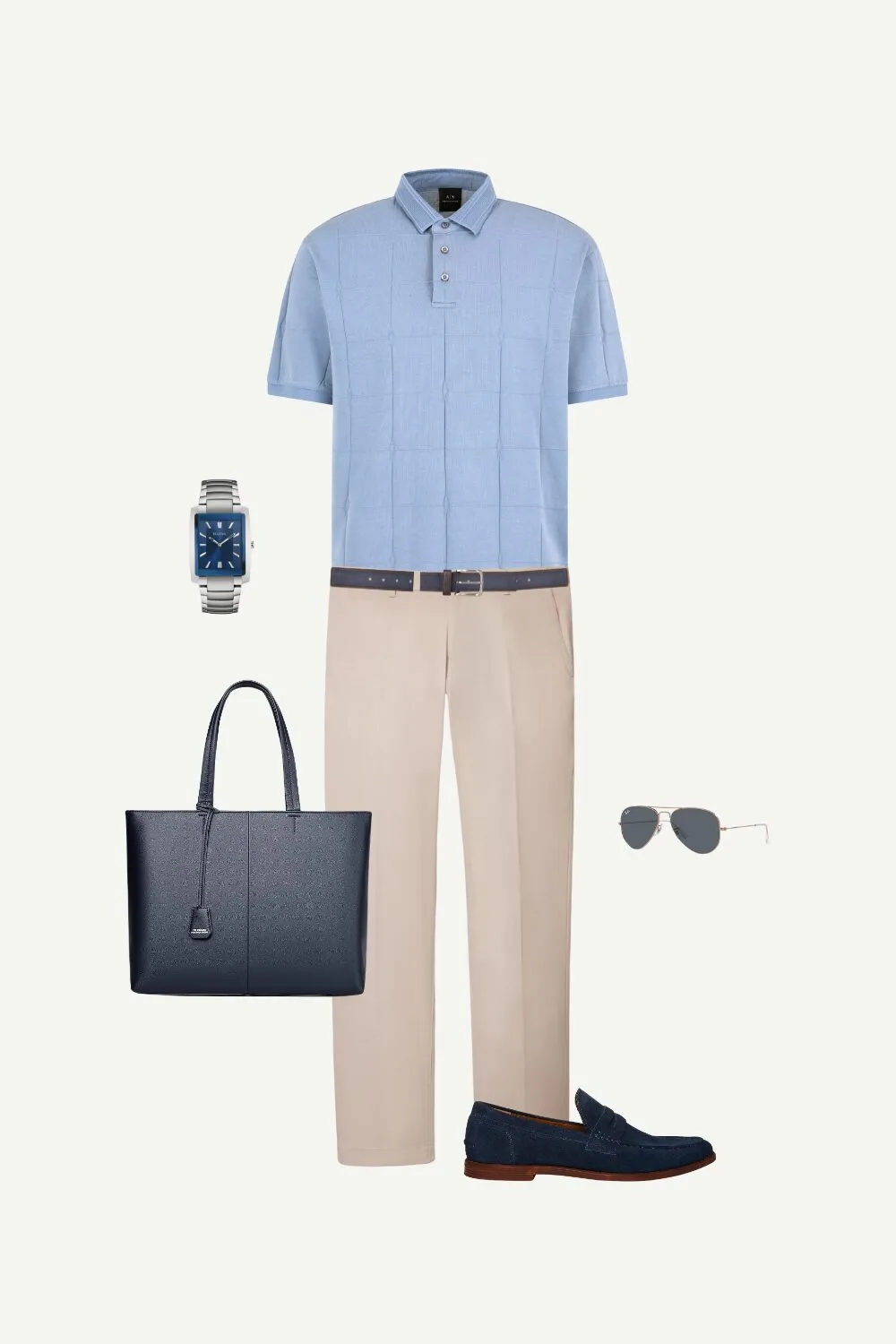Flat lay of a business casual men’s summer outfit featuring a blue polo shirt, beige pants, navy suede loafers, and a navy leather tote bag.