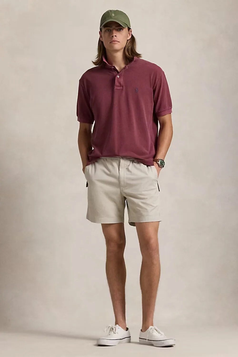 A man wearing a wine-colored polo shirt and beige chino shorts — a clean and casual warm-weather look.