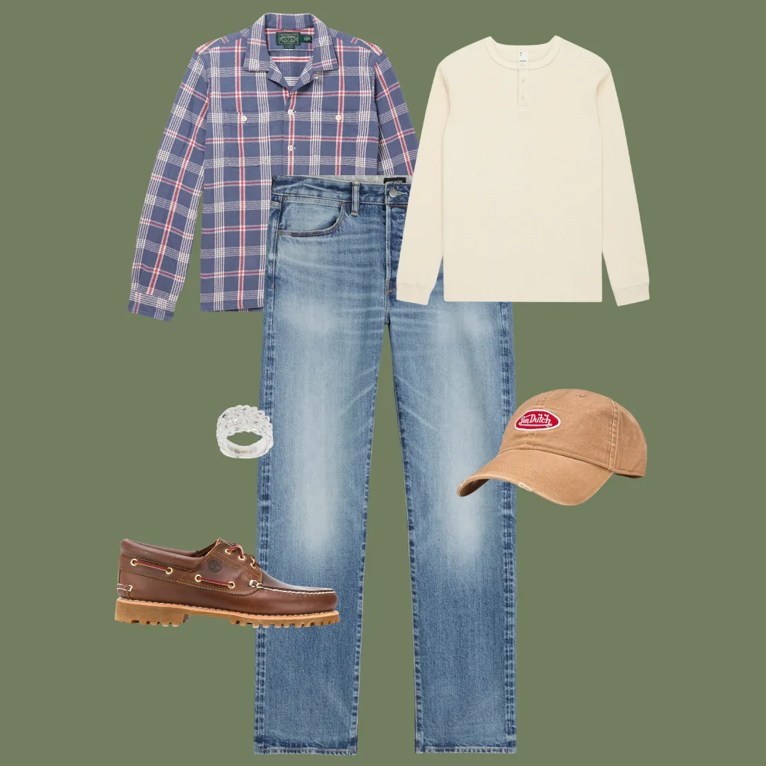 Flat lay of washed-blue straight-fit jeans, a thermal Henley, a plaid flannel shirt, chunky boat shoes, a rough silver ring, and a baseball cap.