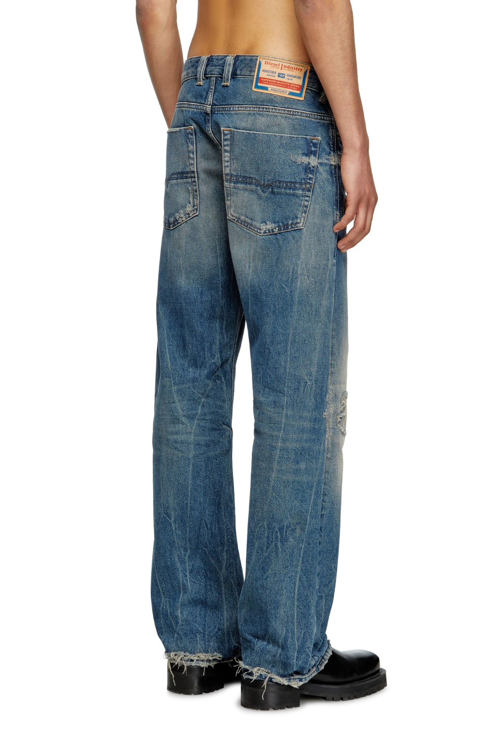 A man wearing Diesel 1980 D-Eepher Distressed Relaxed Jeans in medium blue, shown from the front.