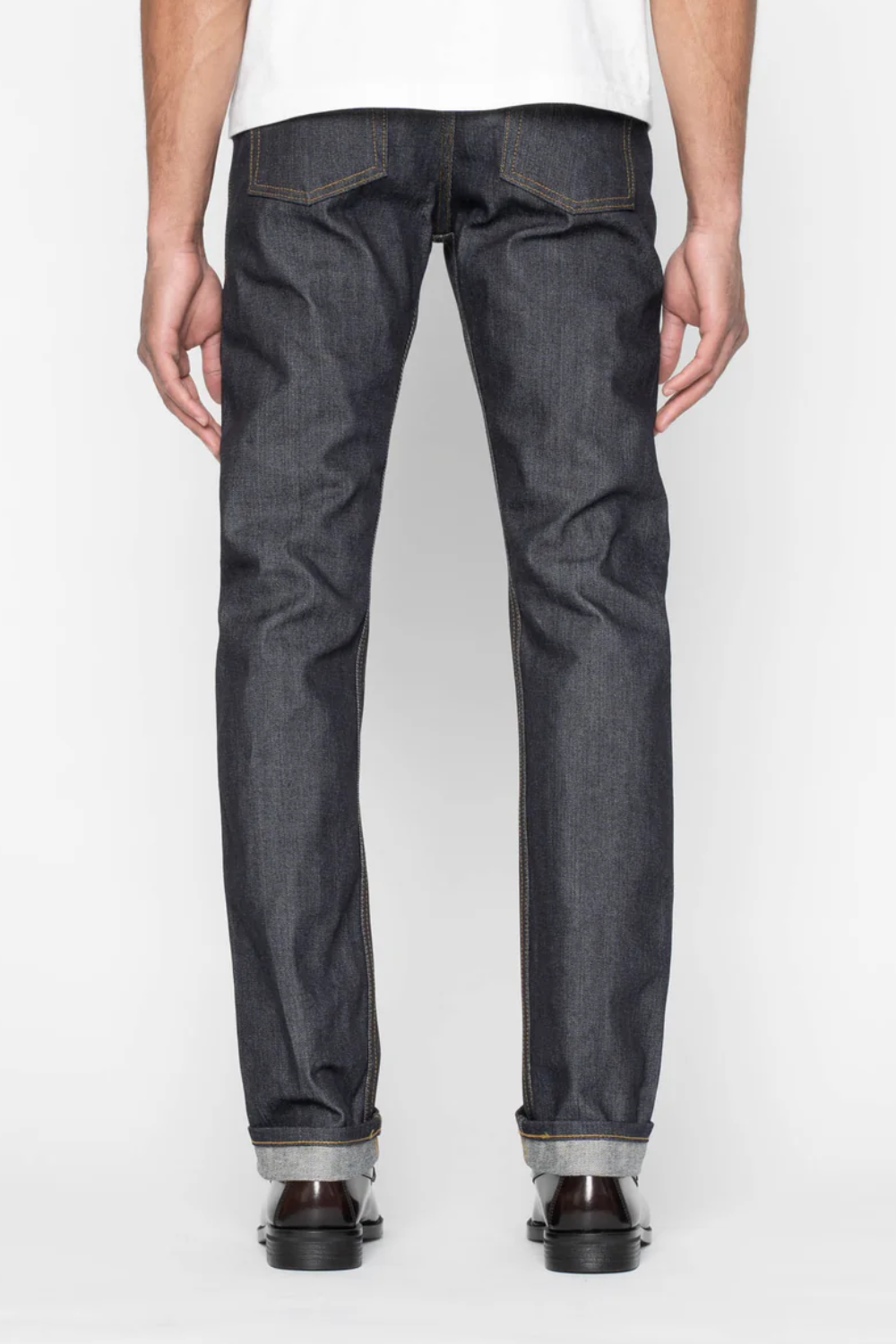 A man wearing Naked & Famous Weird Guy Left-Hand Twill Selvedge Jeans in gray, shown from the back.