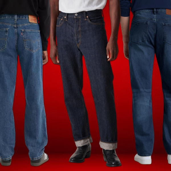 Three men wearing different styles of jeans — vintage blue relaxed fit, raw denim straight leg, and mid-wash regular fit — styled with sneakers and boots against a red background.