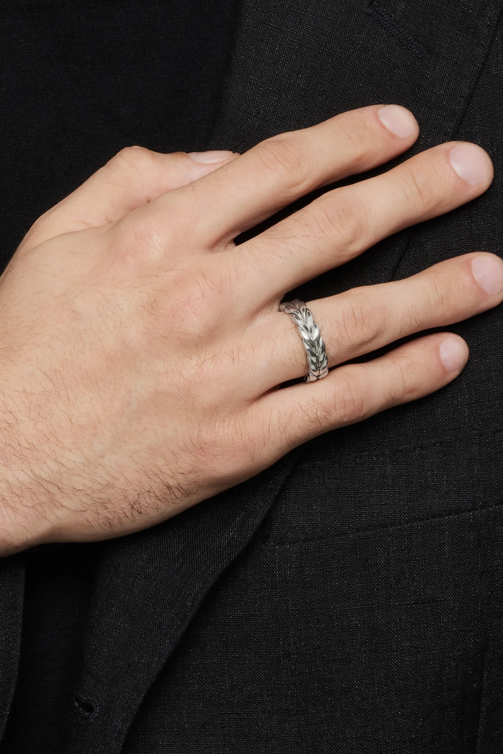 Close-up image of a man’s hand wearing the David Yurman sterling silver Chevron band ring, highlighting the engraved chevron pattern and signature polished edges.