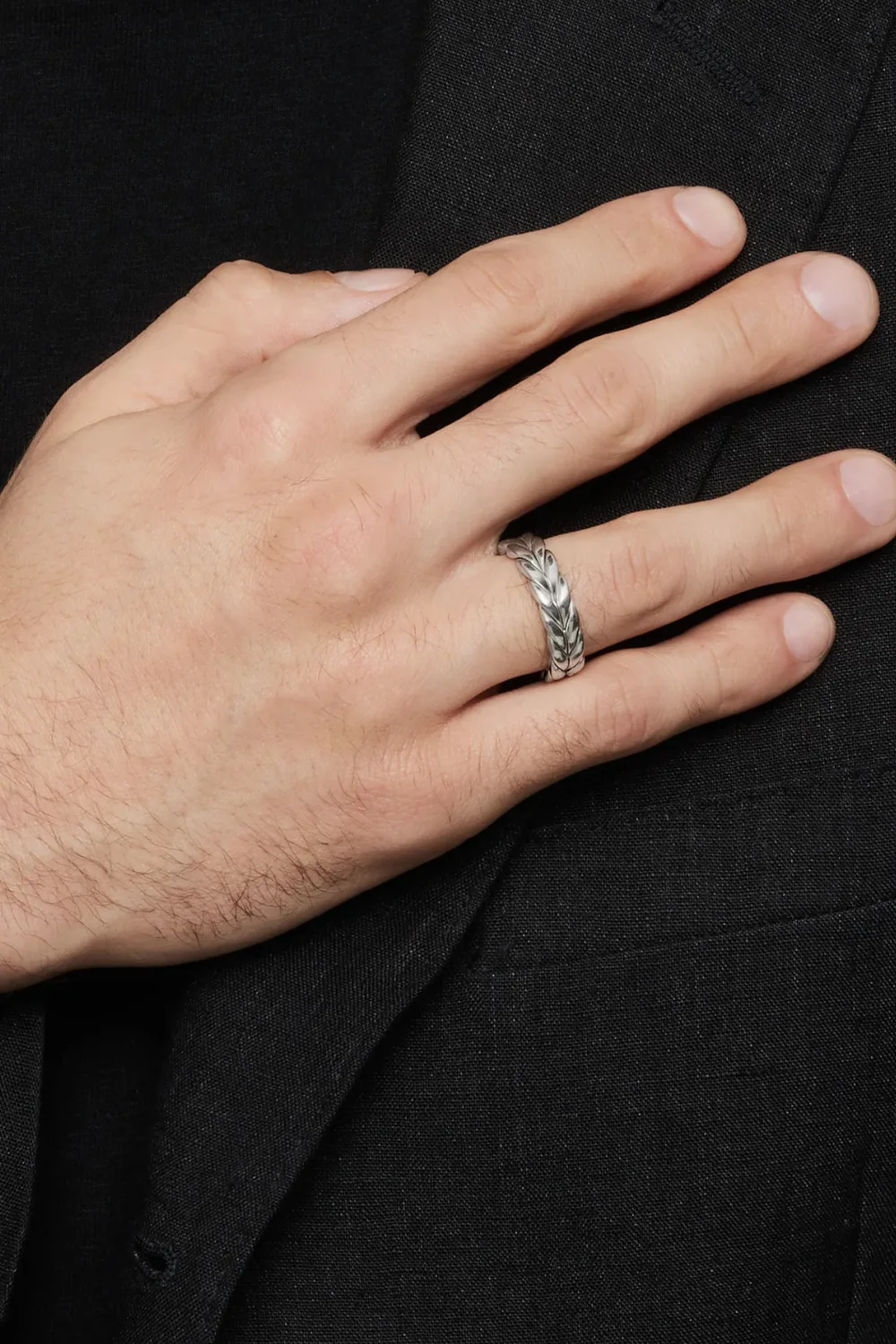 Close-up image of a man’s hand wearing the David Yurman sterling silver Chevron band ring, highlighting the engraved chevron pattern and signature polished edges.
