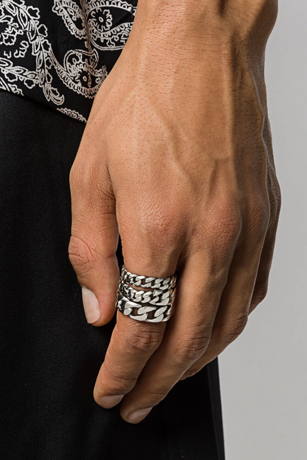 Close-up shot of a man’s hand wearing the Emanuele Bicocchi stacked cable chain ring, featuring layered chain links and a textured oxidized silver finish.