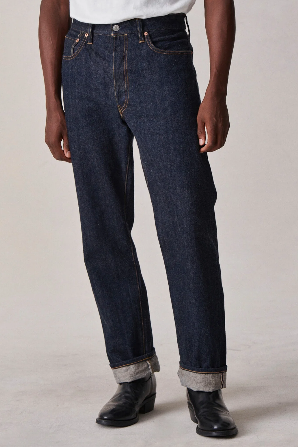 A man wearing Buck Mason Japanese Loomstate Selvedge Full Saddle Jeans in dark indigo, shown from the front.