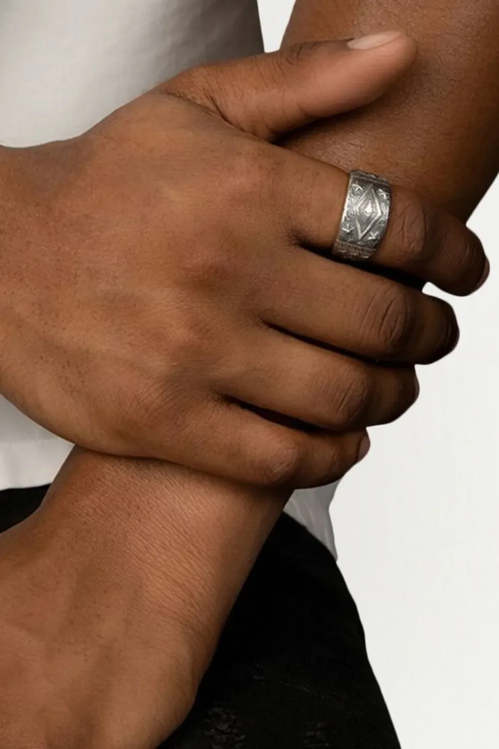 Close-up shot of a man’s hand wearing the Nialaya Jewelry engraved vintage-style ring, featuring ornate detailing and an aged silver finish that gives it a classic, worn-in look.