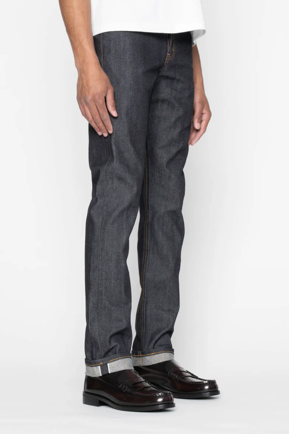 A man wearing Naked & Famous Weird Guy Left-Hand Twill Selvedge Jeans in gray, side view.