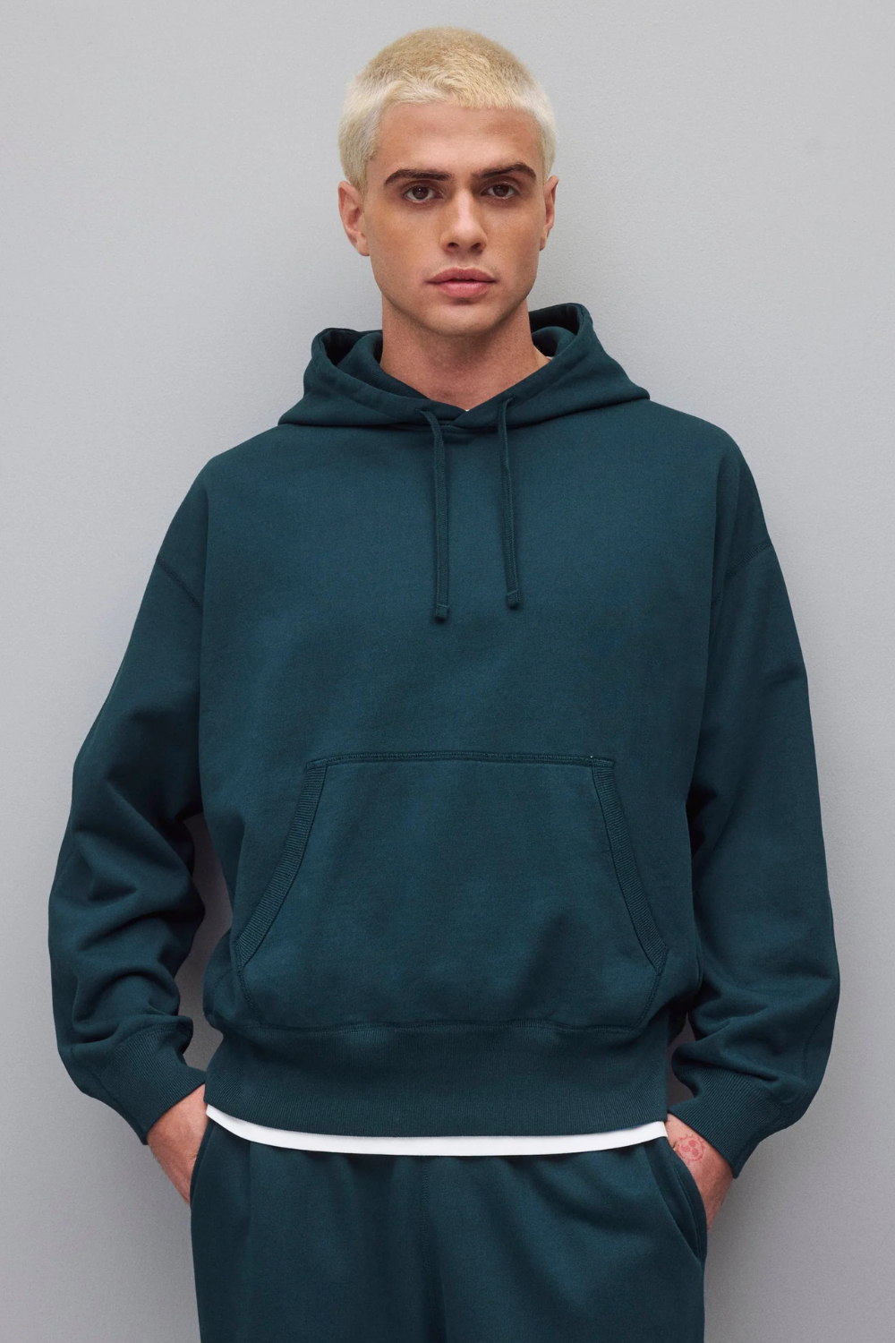 Man Wearing Reigning Champ Midweight Terry Hoodie in Green