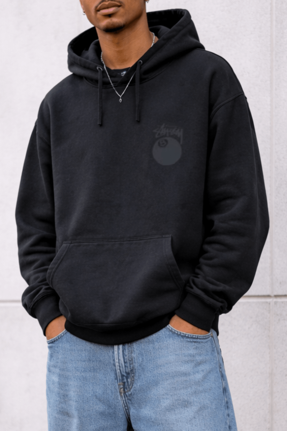Man Wearing Stussy 8 Ball Pigment Dyed Hoodie in Black