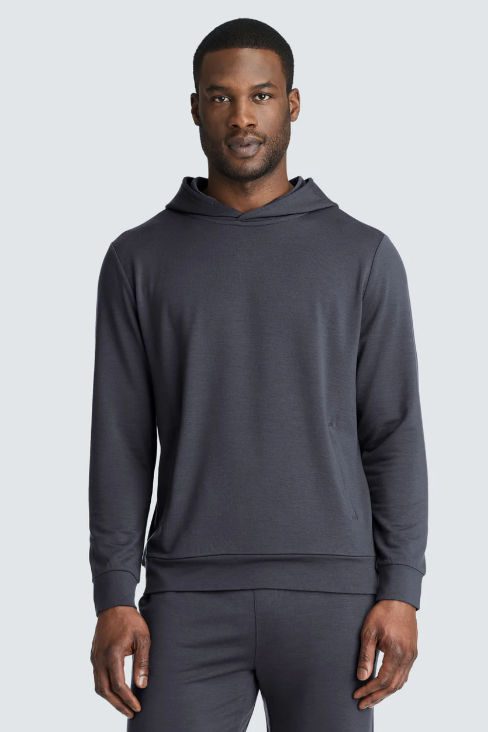 Man Wearing Unbound Merino Transit Hoodie in Charcoal