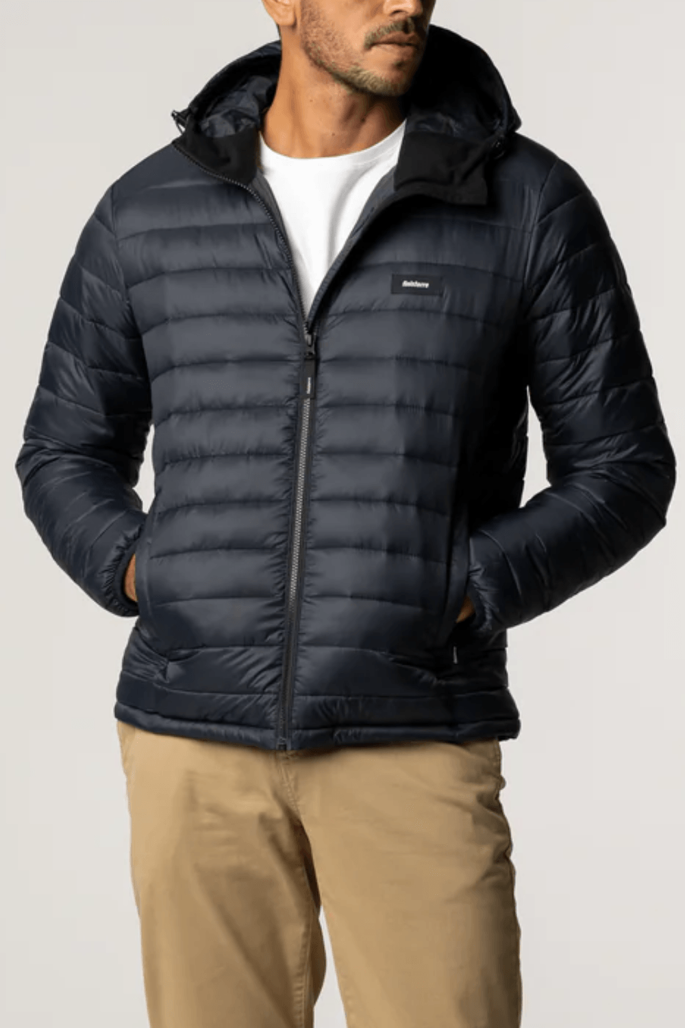 Man Wearing Finisterre Men's recycled insulated puffer jacket in black featuring NetPlus