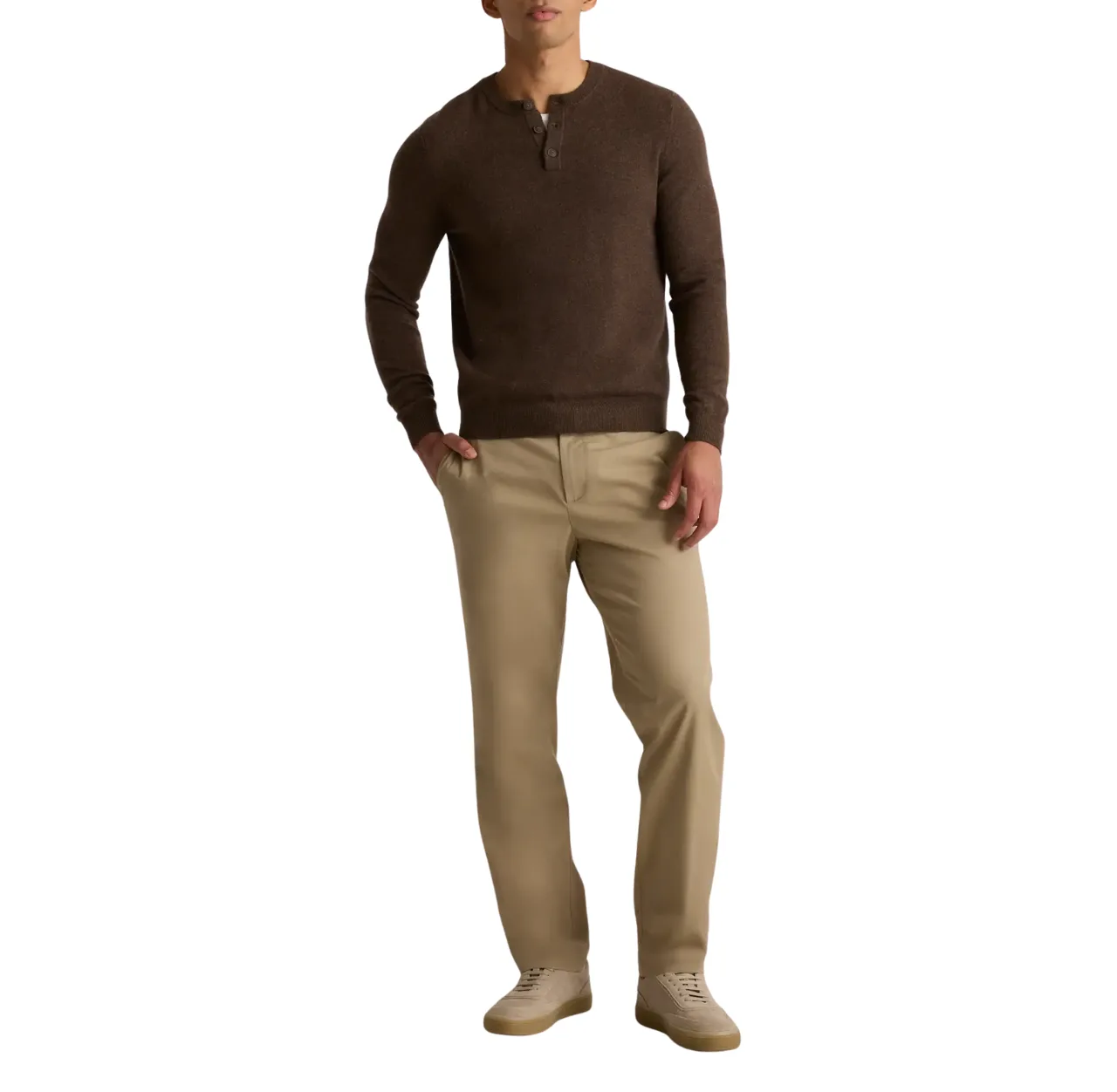Man wearing a brown henley shirt with khaki chinos and sand-colored leather sneakers, standing with one hand in his pants pocket.