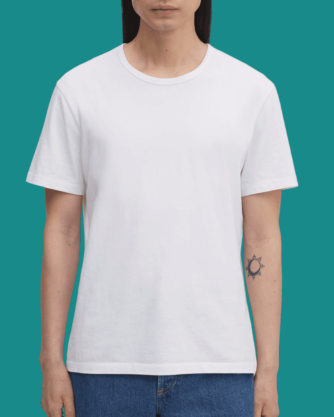 Man wearing Asket The White T-Shirt, standing casually with arms relaxed at his sides.