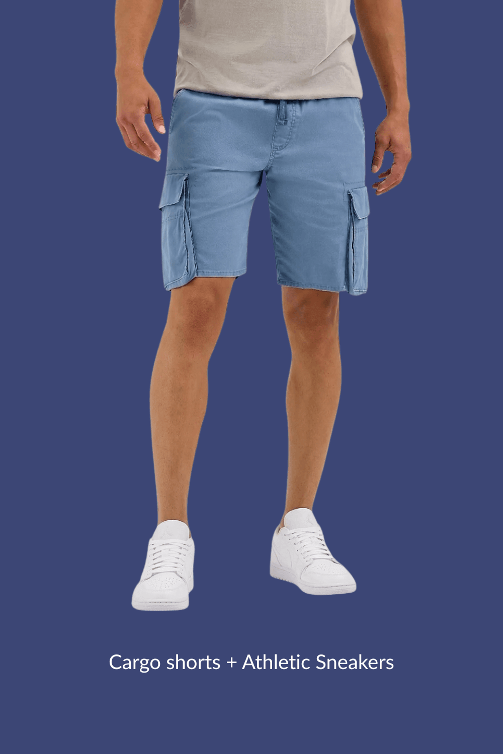 Man wearing blue cargo shorts and white Jordan 1 Lows, standing casually with arms relaxed at sides.