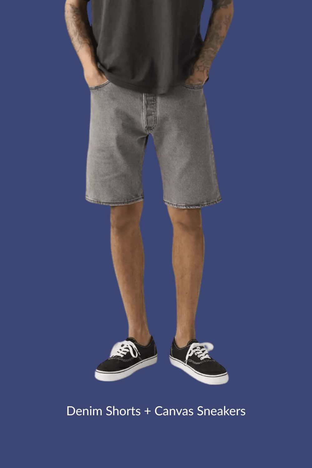 Man in gray denim shorts and black canvas sneakers with hands in pockets, standing casually.