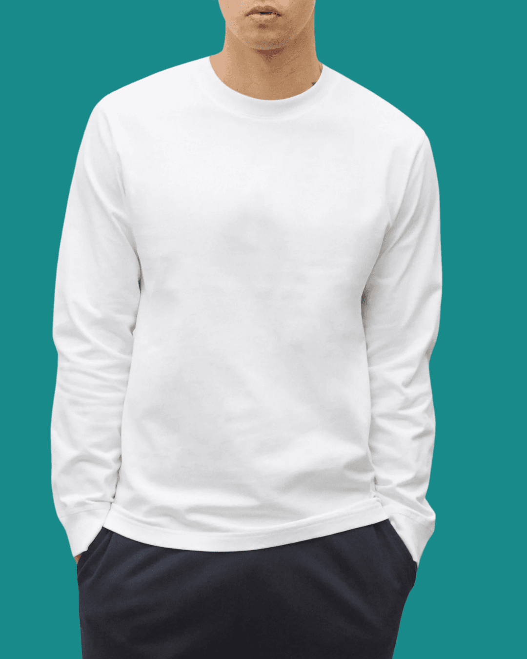 Man in Reigning Champ Midweight Long Sleeve White Tee with hands in pockets, standing casually.