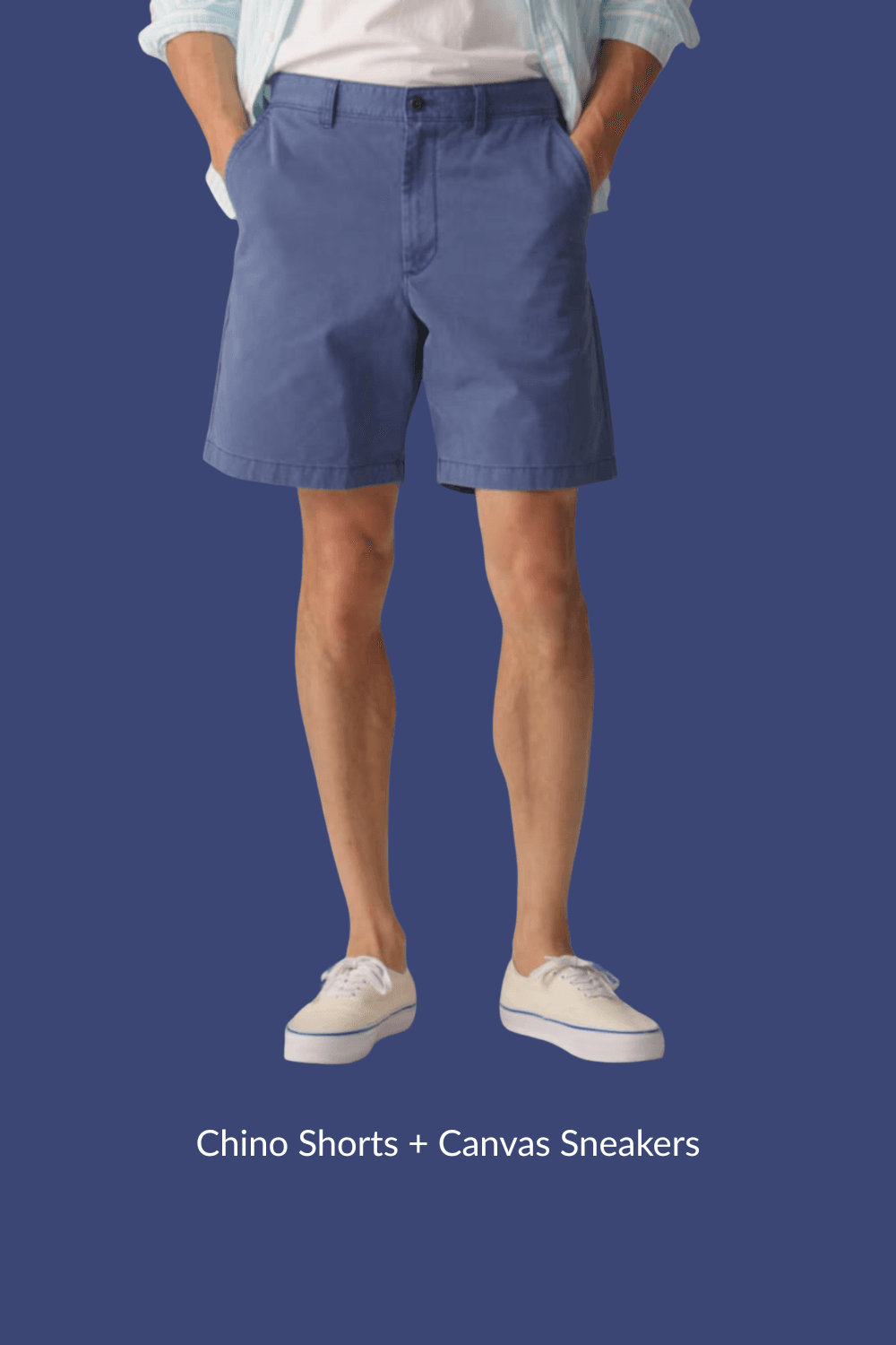 Man in blue chino shorts and beige canvas sneakers with hands in pockets, standing casually.