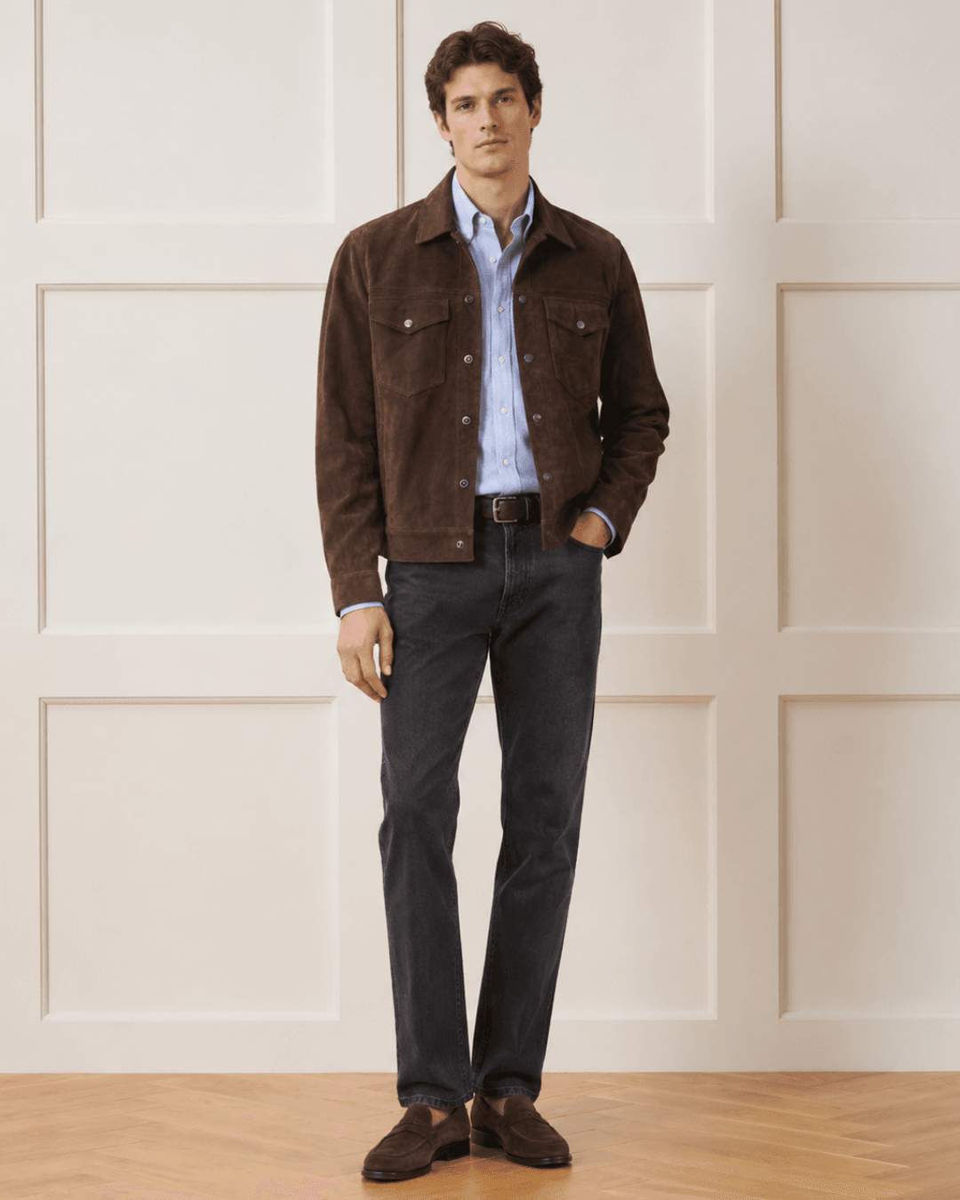 Man wearing a Chocolate brown suede trucker, a Pale blue Oxford shirt, Faded black straight-leg jeans, and Dark brown suede loafers