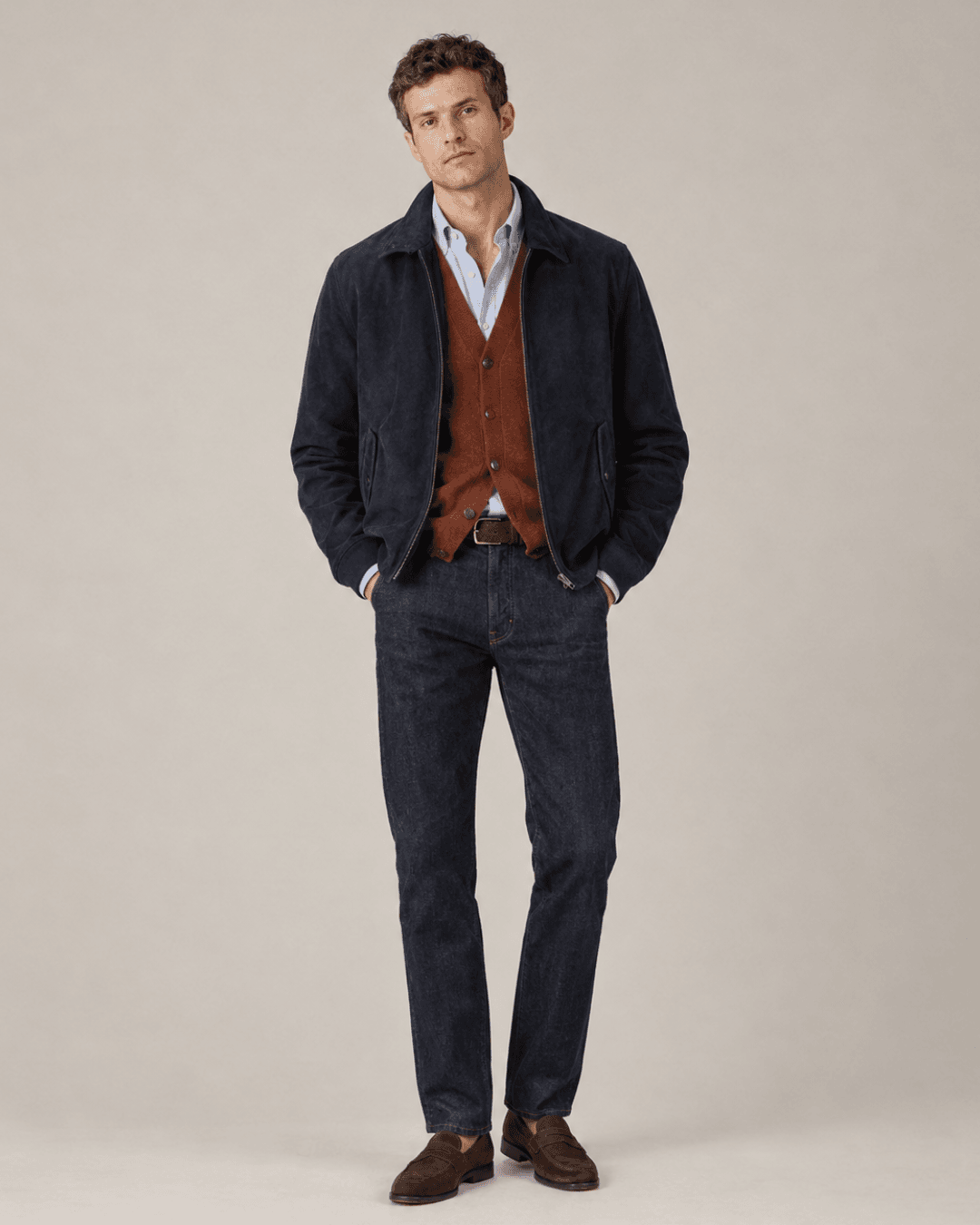 Man wearing a Navy Suede Harrington, a Rust merino cardigan, Washed-blue jeans, Dark brown suede loafers