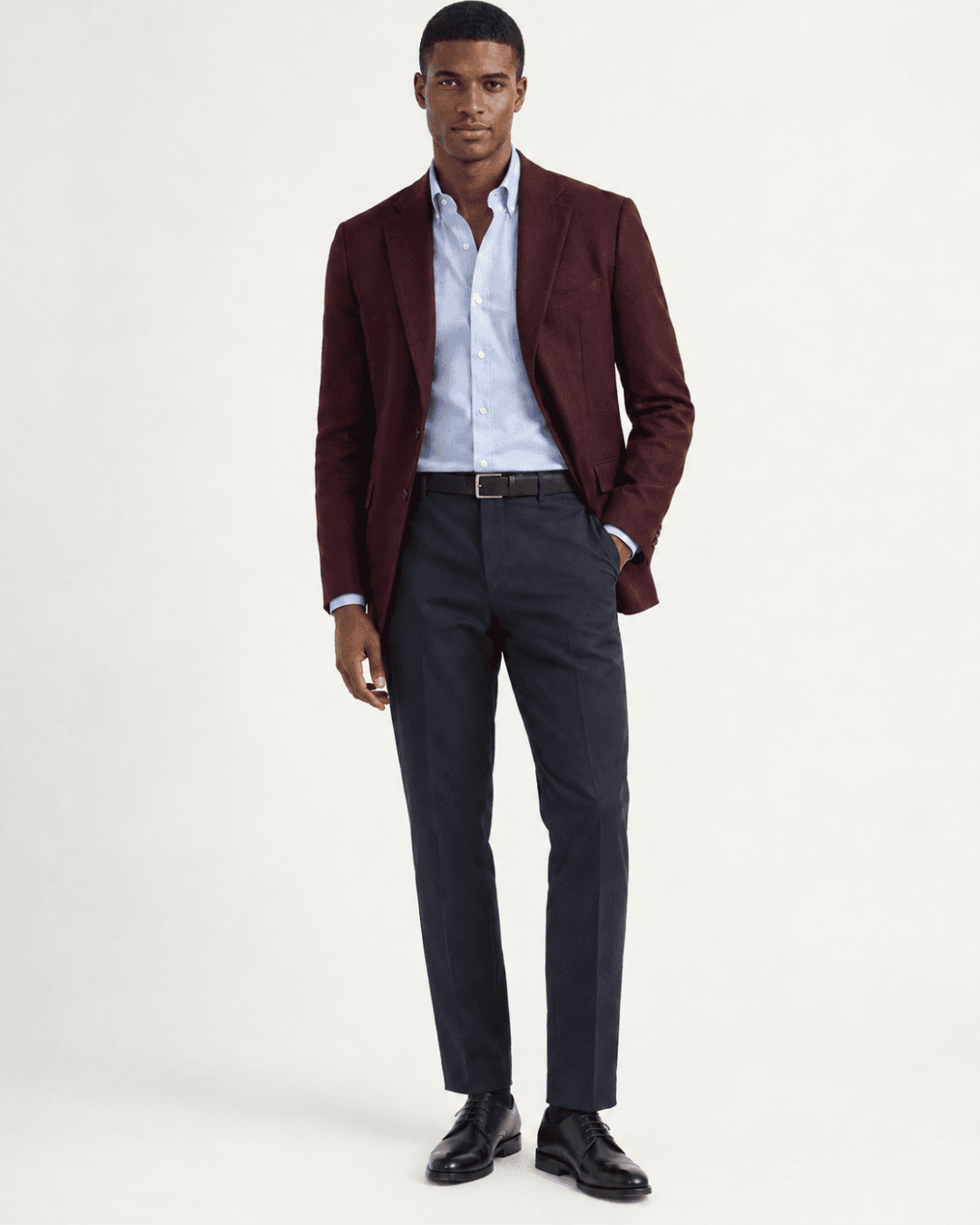 Man wearing a Burgundy Blazer, Navy trousers, a Pale Blue Oxford, and Black Leather Derbies